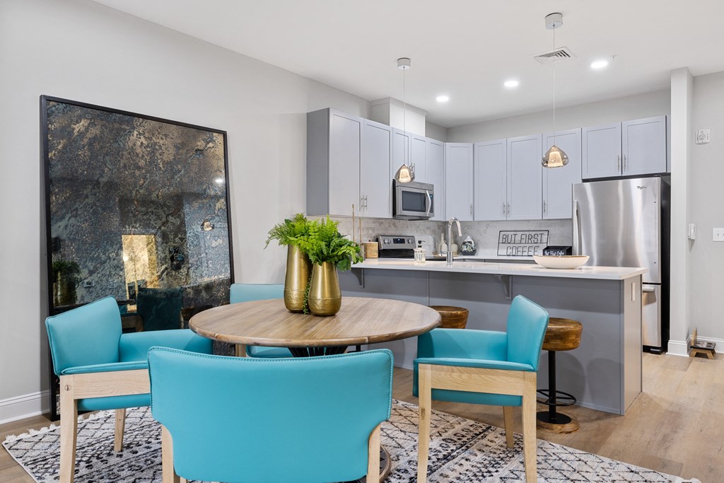 an open kitchen and dining room with blue chairs and a table