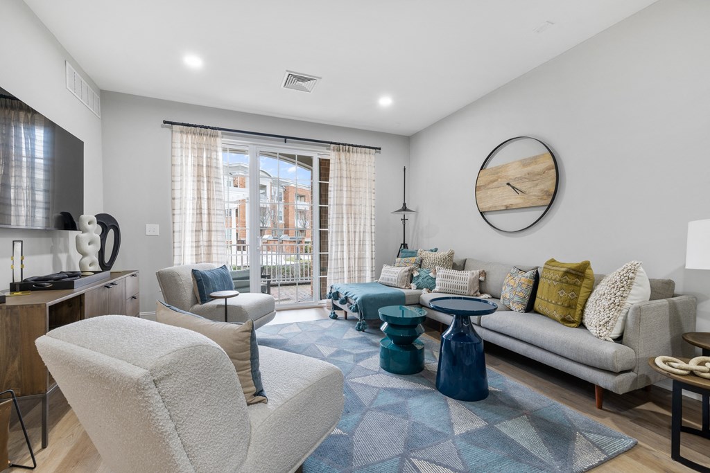 a living room with couches and chairs and a sliding glass door