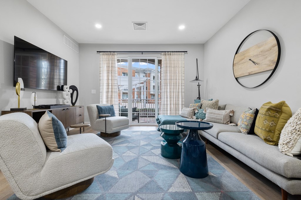 A modern living room with a large window and a view of a building outside.