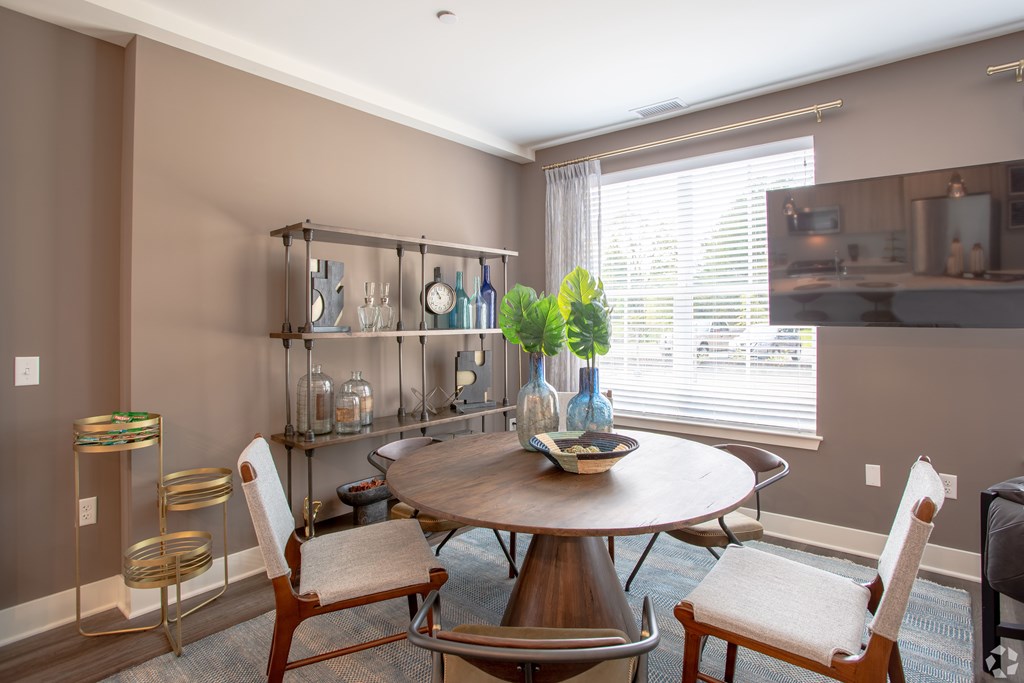 A dining room with a round table and chairs.