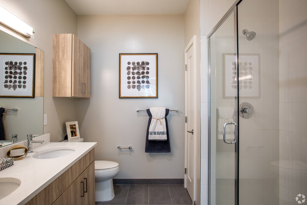 A bathroom with a toilet, sink, and shower.
