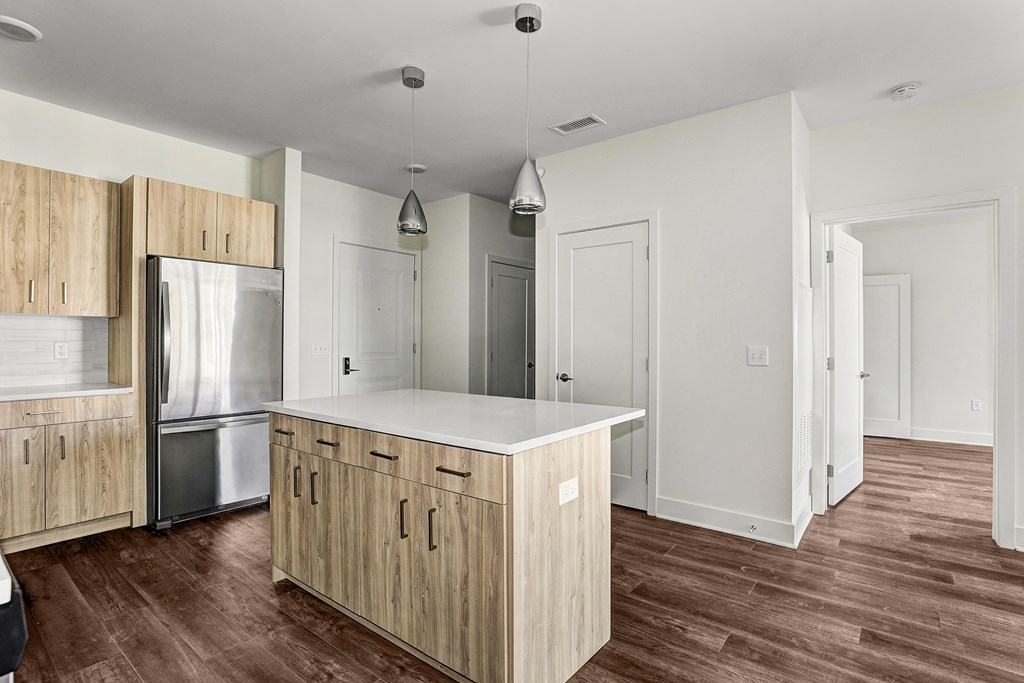 A kitchen with wooden cabinets and a stainless steel refrigerator.