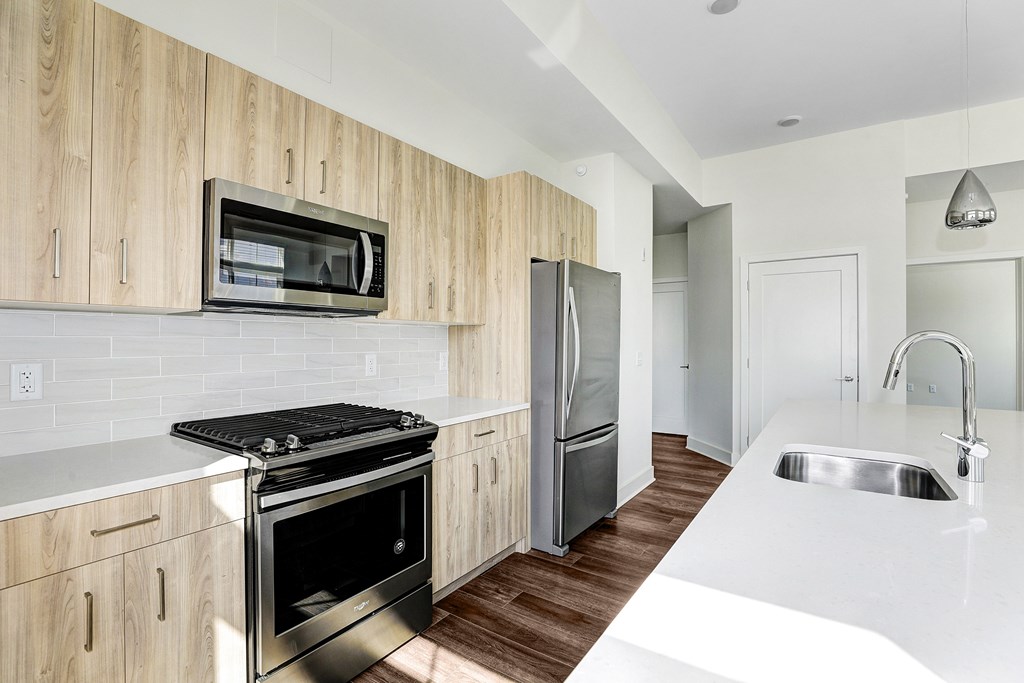 A modern kitchen with wooden cabinets and stainless steel appliances.