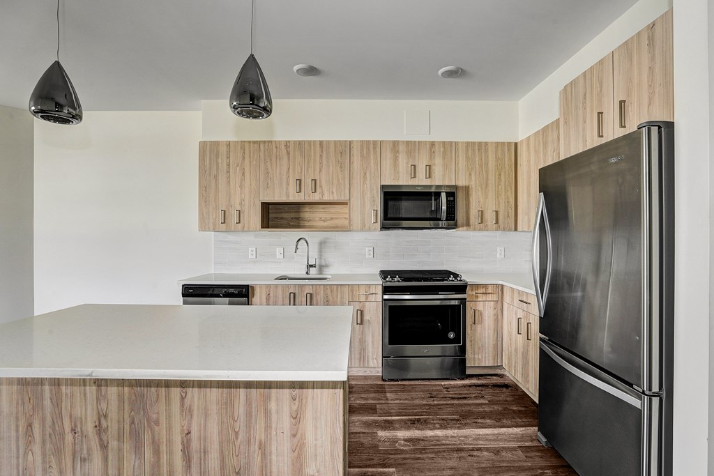 A modern kitchen with wooden cabinets and stainless steel appliances.