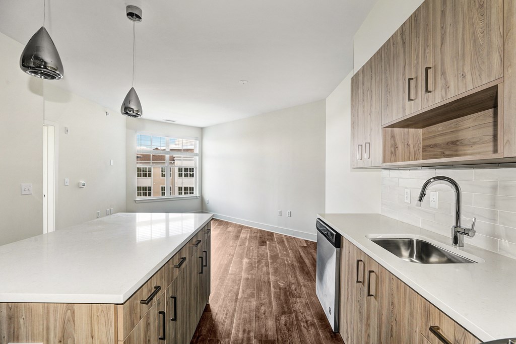 A modern kitchen with wooden cabinets and a white countertop.
