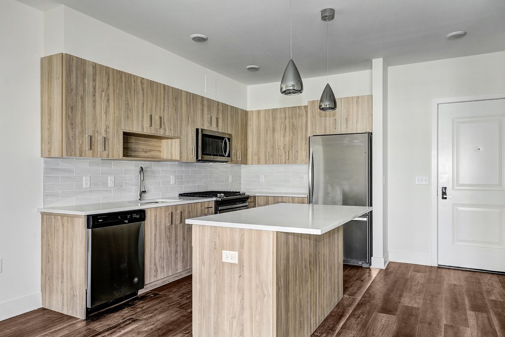 A modern kitchen with wooden cabinets and a white countertop.