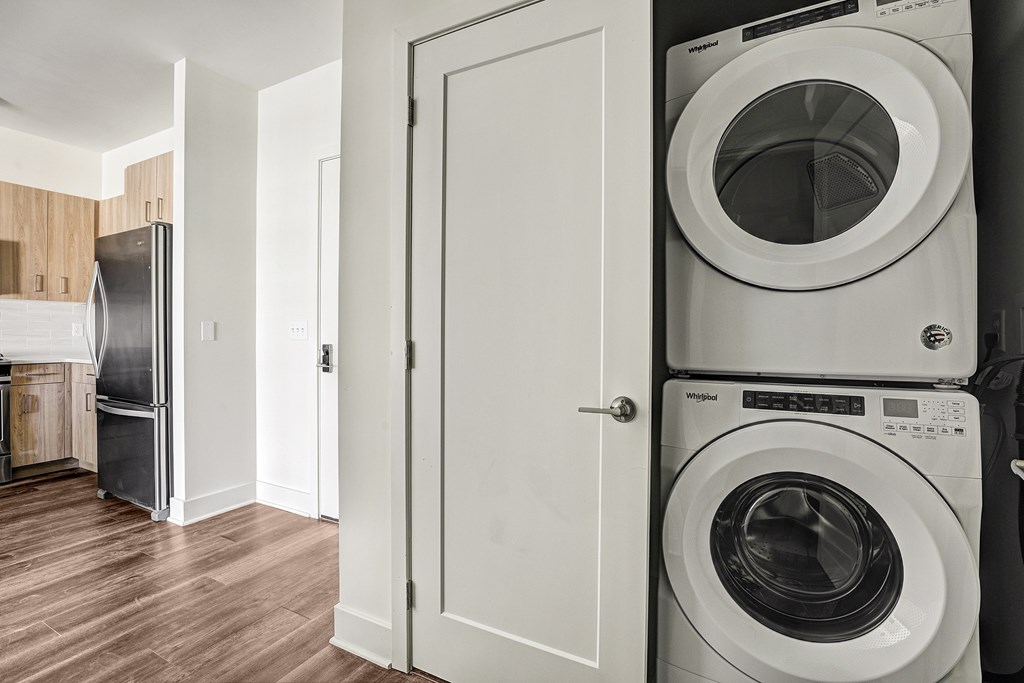 A white door is open to a laundry room with a washer and dryer.