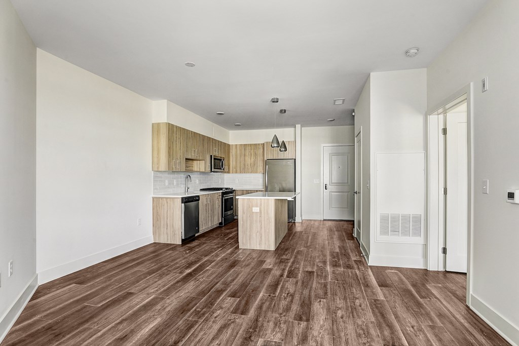 A kitchen with wooden floors and white walls.