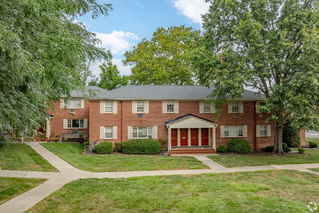 A red brick house with a green lawn in front.