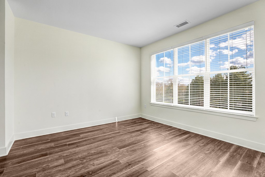 A room with a window and wooden flooring.