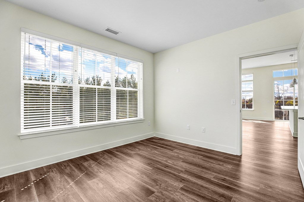 A room with a window and wooden flooring.