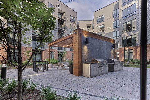 A modern outdoor kitchen area with a grill and seating area.