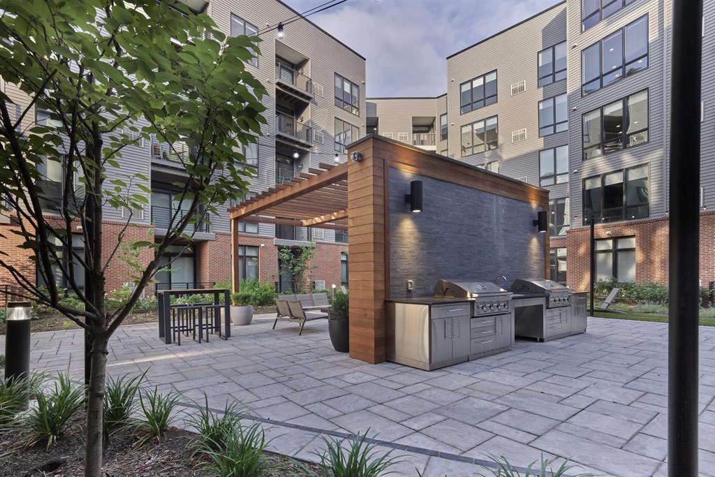 A modern outdoor kitchen area with a grill and seating area.
