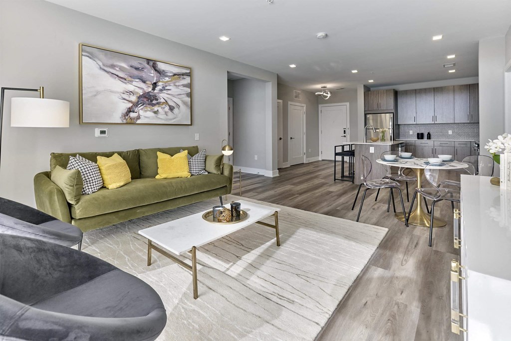 A modern living room with a green sofa and a grey chair.
