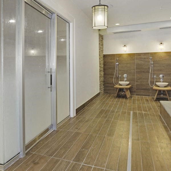 a bathroom with two urinals and two sinks and a shower