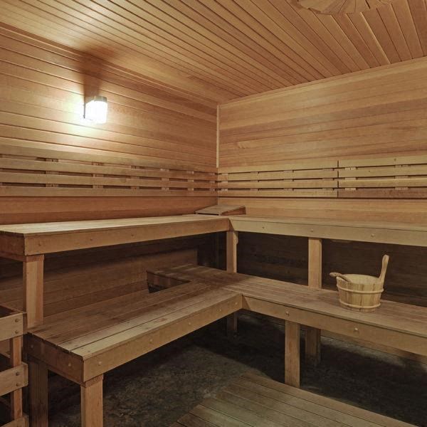 a wooden sauna with benches and a bucket