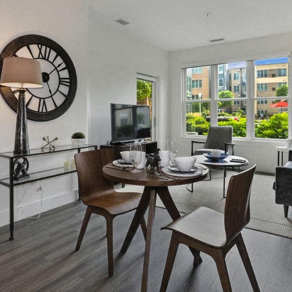 a living room with a table and a clock on the wall