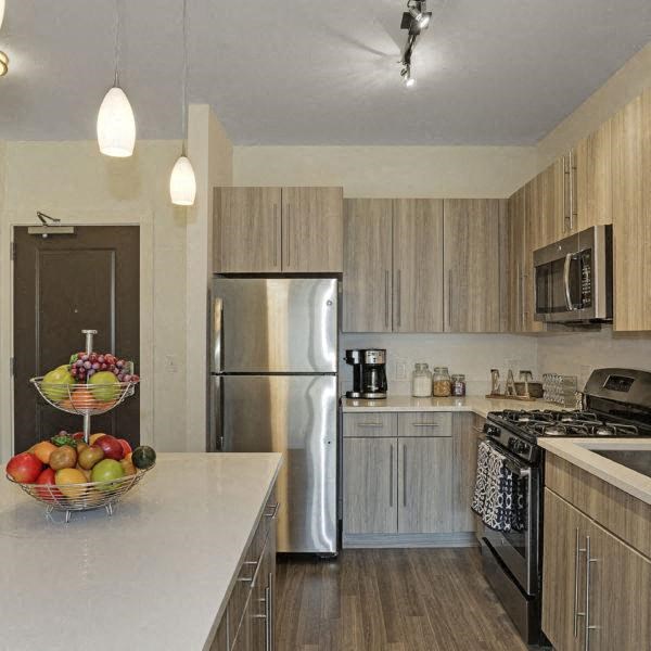 a kitchen with stainless steel appliances and a bowl of fruit