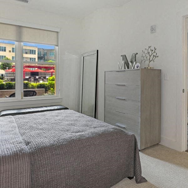 a bedroom with a bed and a large window