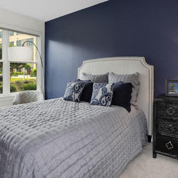 a bedroom with a bed and a blue wall