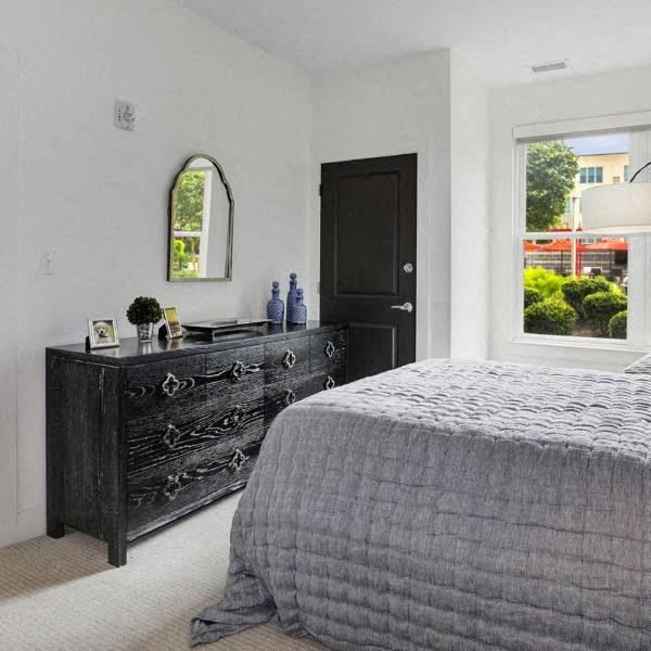 a bedroom with a bed and a black dresser