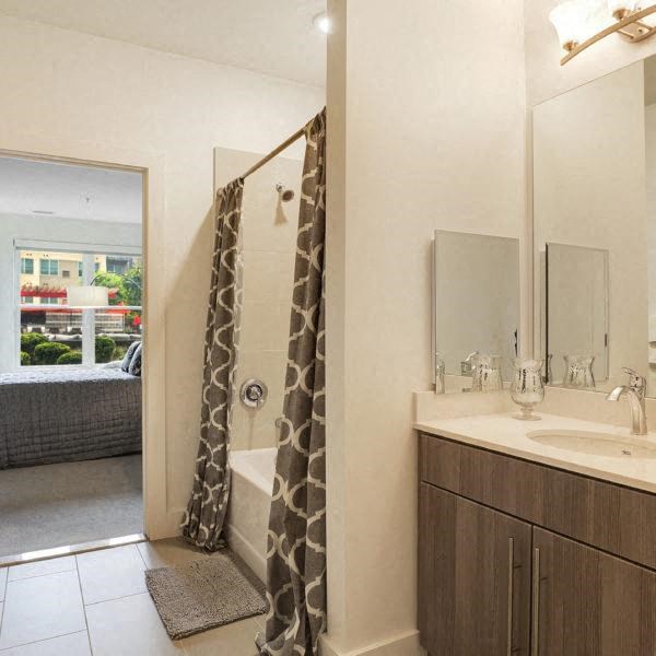 a bathroom with a shower and a sink and a mirror