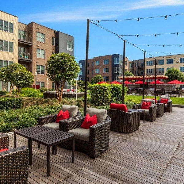 a patio with chairs and tables on a wooden deck