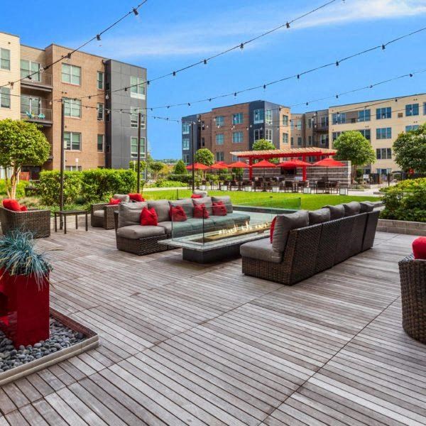 a large deck with couches and a fire pit