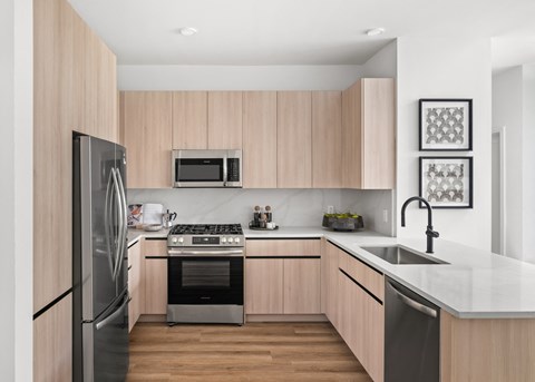 a modern kitchen with wooden cabinets and stainless steel appliances