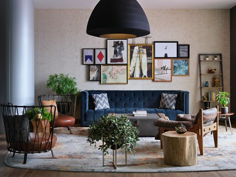 A living room with a blue couch and a rug.