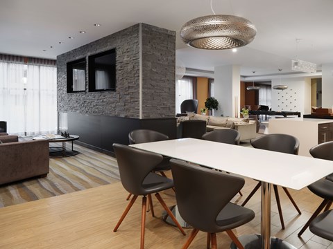 A modern dining room with a stone accent wall and a large table with chairs.