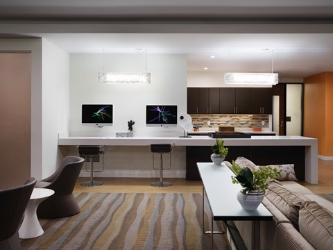 A modern living room with a bar area and a kitchen in the background.