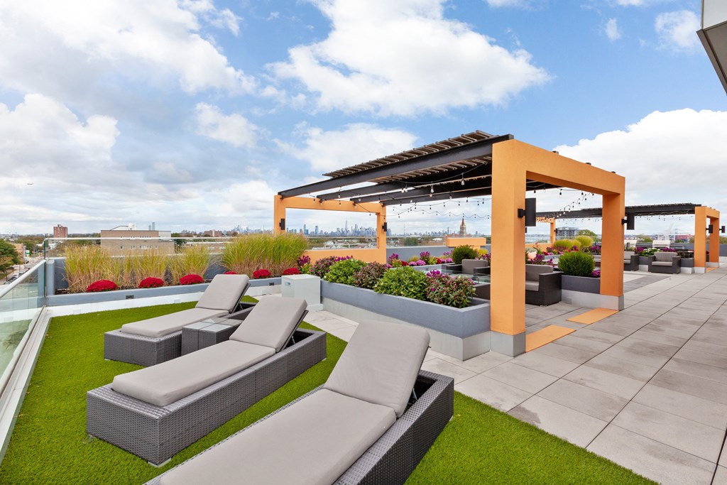 a roof deck with couches and a pergola