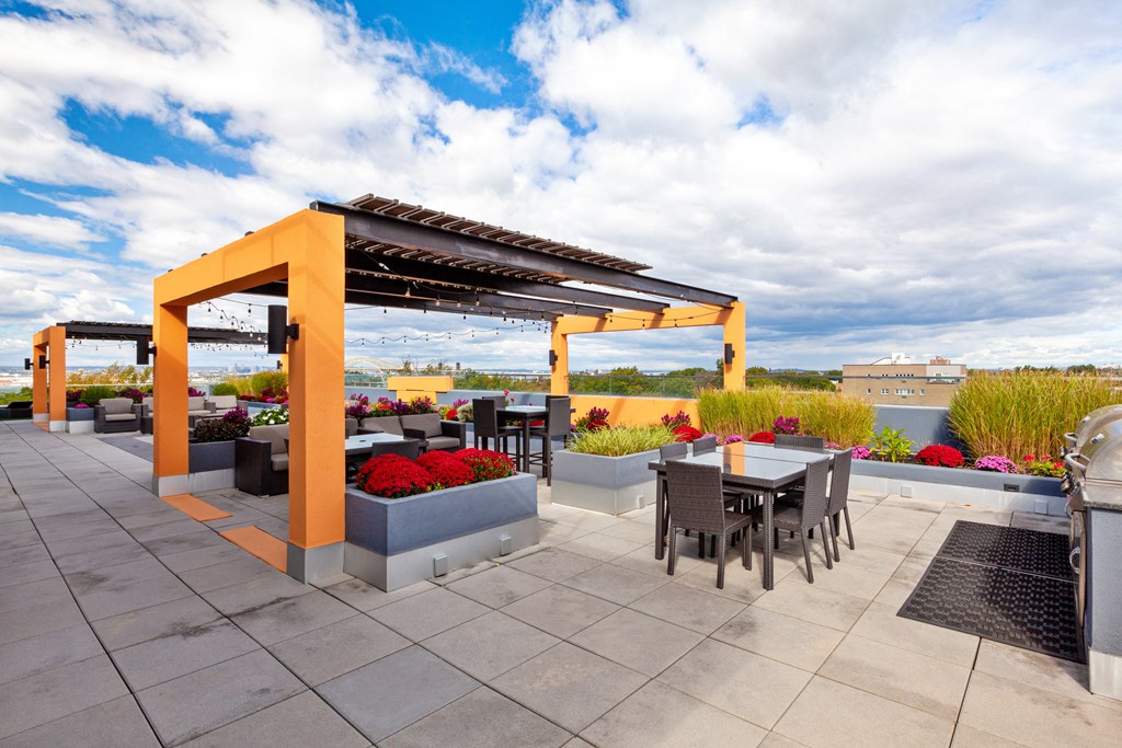 an outdoor patio with tables and chairs and a pergola