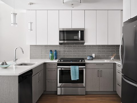 A modern kitchen with a black refrigerator and stainless steel appliances.