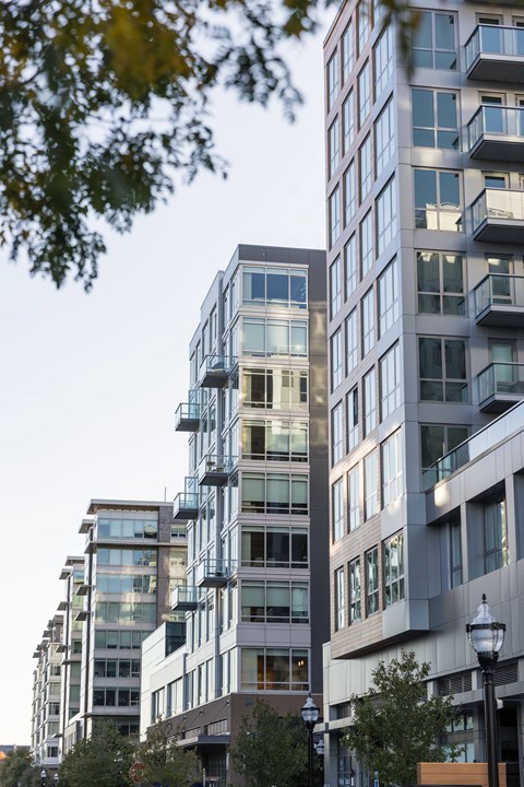 A row of modern buildings with glass windows and balconies.
