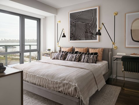 A bedroom with a large bed and a view of the city.