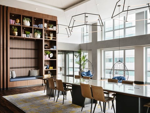 A modern dining room with a long table and chairs.