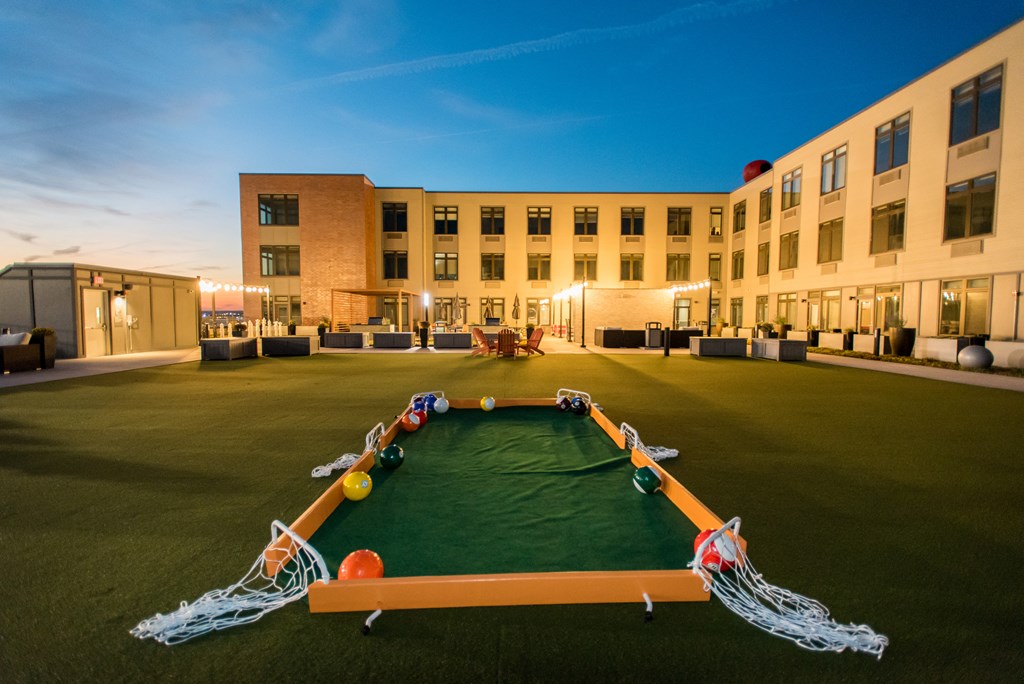 a courtyard with a large pool with soccer equipment in front of a building