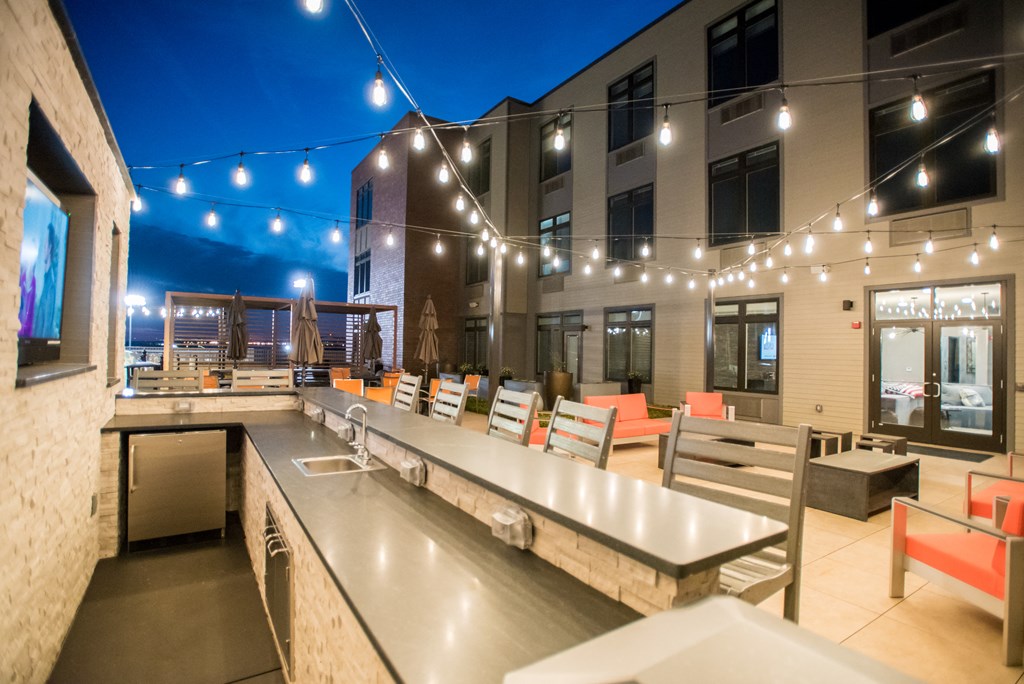 a communal area with tables and chairs at a building with lights