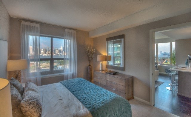 a bedroom with a bed and a view of the city