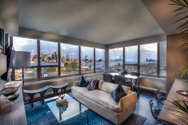 a living room with a white couch and a view of a city skyline