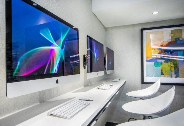 a computer room with three monitors and a keyboard and mouse