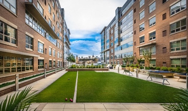 an outdoor area with a lawn and buildings in the background