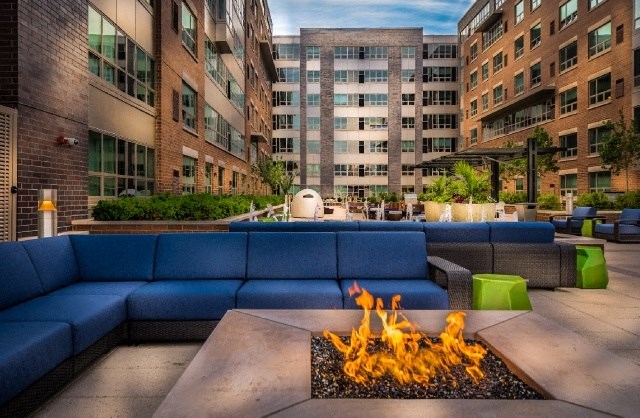 a lounge area with a fire pit in the middle