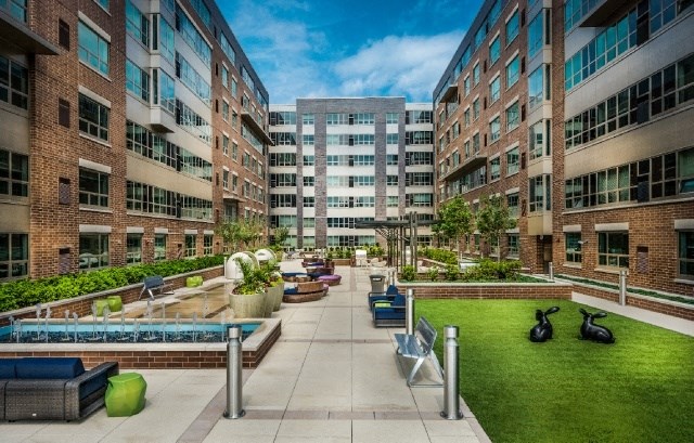 an open courtyard with a pool and benches in front of buildings