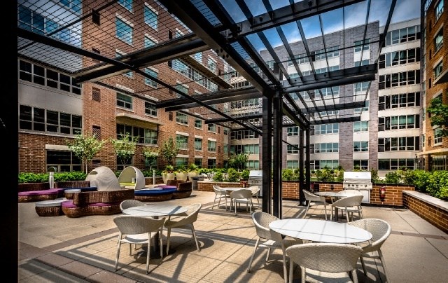 an outdoor patio with tables and chairs and a large glass roof