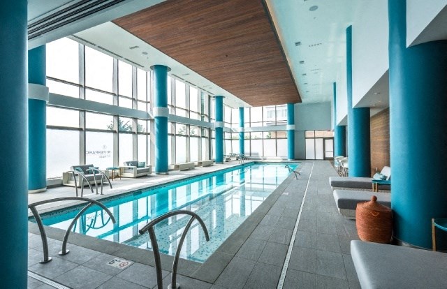 a swimming pool in a large room with floor to ceiling windows