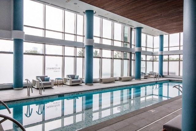 a swimming pool in a building with large windows