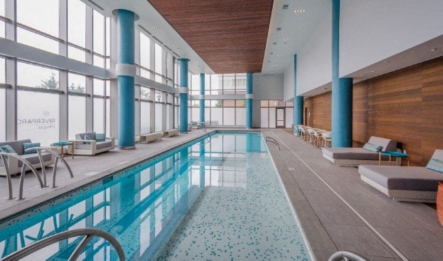 a swimming pool in a large room with floor to ceiling windows
